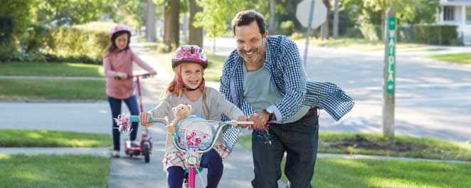 a man helping a child ride a bike