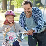 un hombre ayudando a un niño a andar en bicicleta